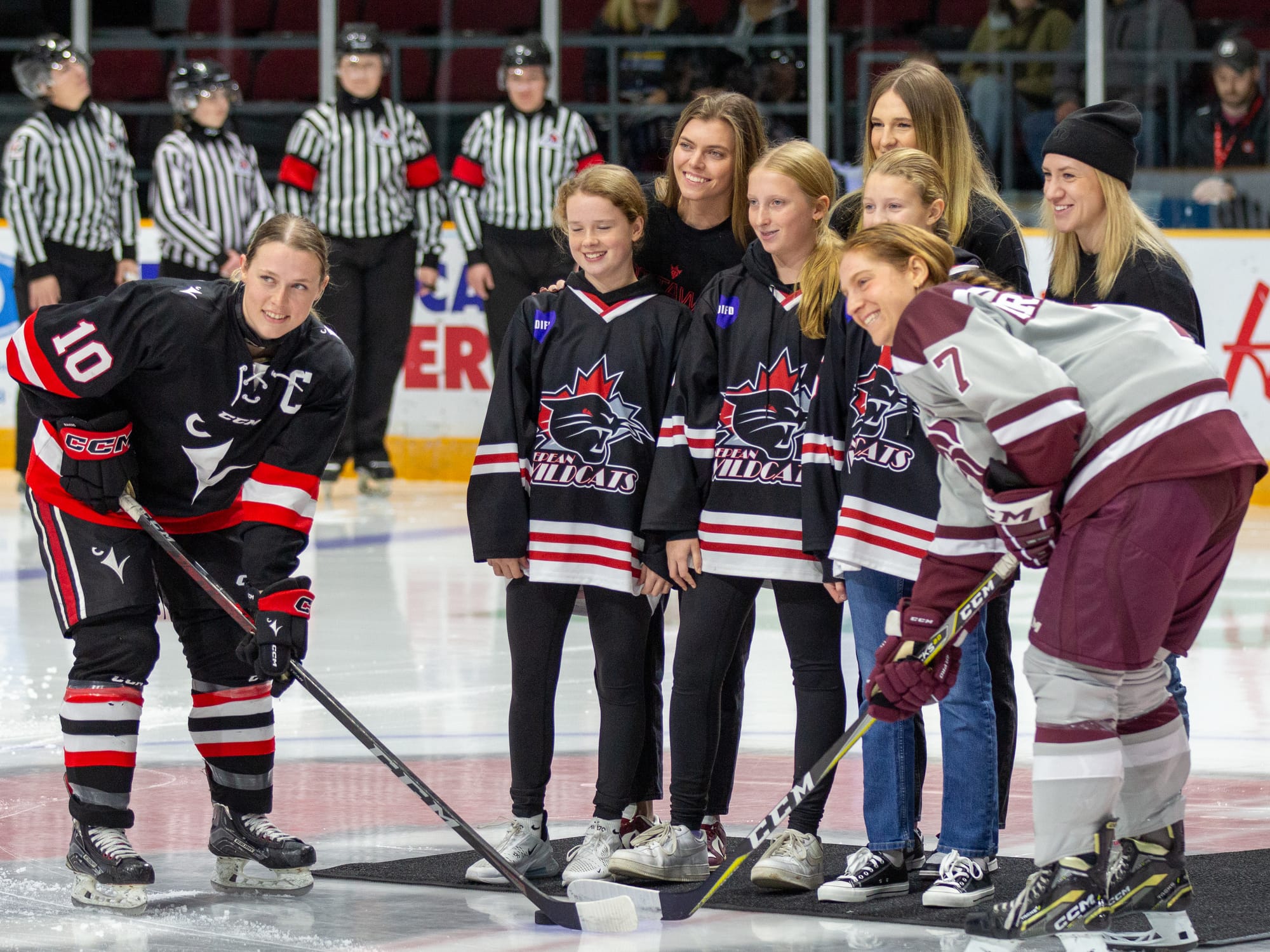 The Carleton and uOttawa Captains take the ceremonial faceoff, dropped by three girls-team players and three PWHL players. 