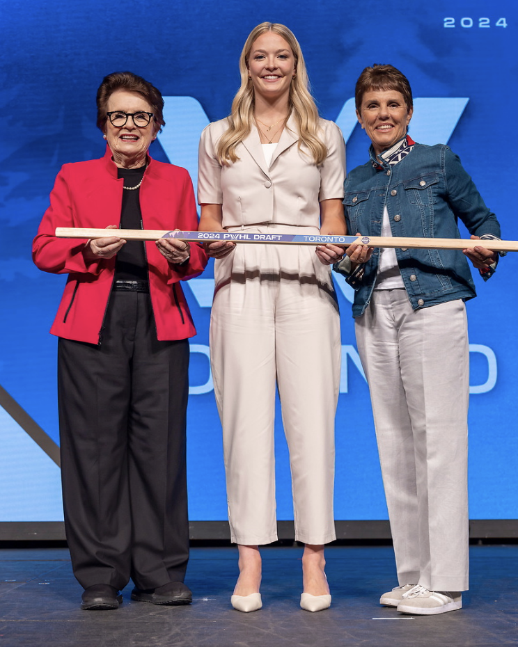 From left to right, King, Gosling and Kloss hold a wooden stick and smile at the camera on stage at the 2024 draft.