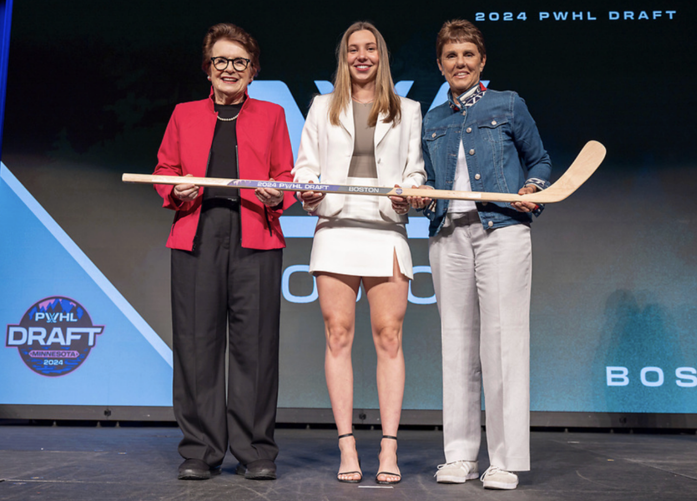 Bilka poses with a draft stick. She is standing between Billie Jean King and Ilana Kloss. They're all smiling.