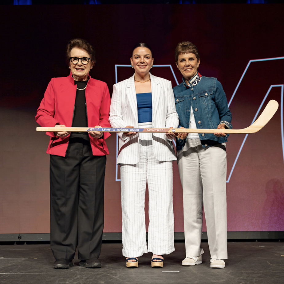 From left to right: King, Barnes and Kloss pose with a wooden stick on stage at the PWHL draft.