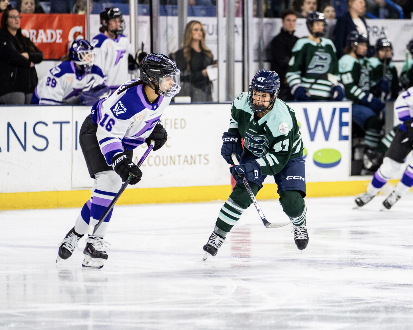 Jaques (left in white) leans forward and looks to her left, watching the play out of the frame. Rattray (right in green), push off her right foot as she looks to get back into the play. 