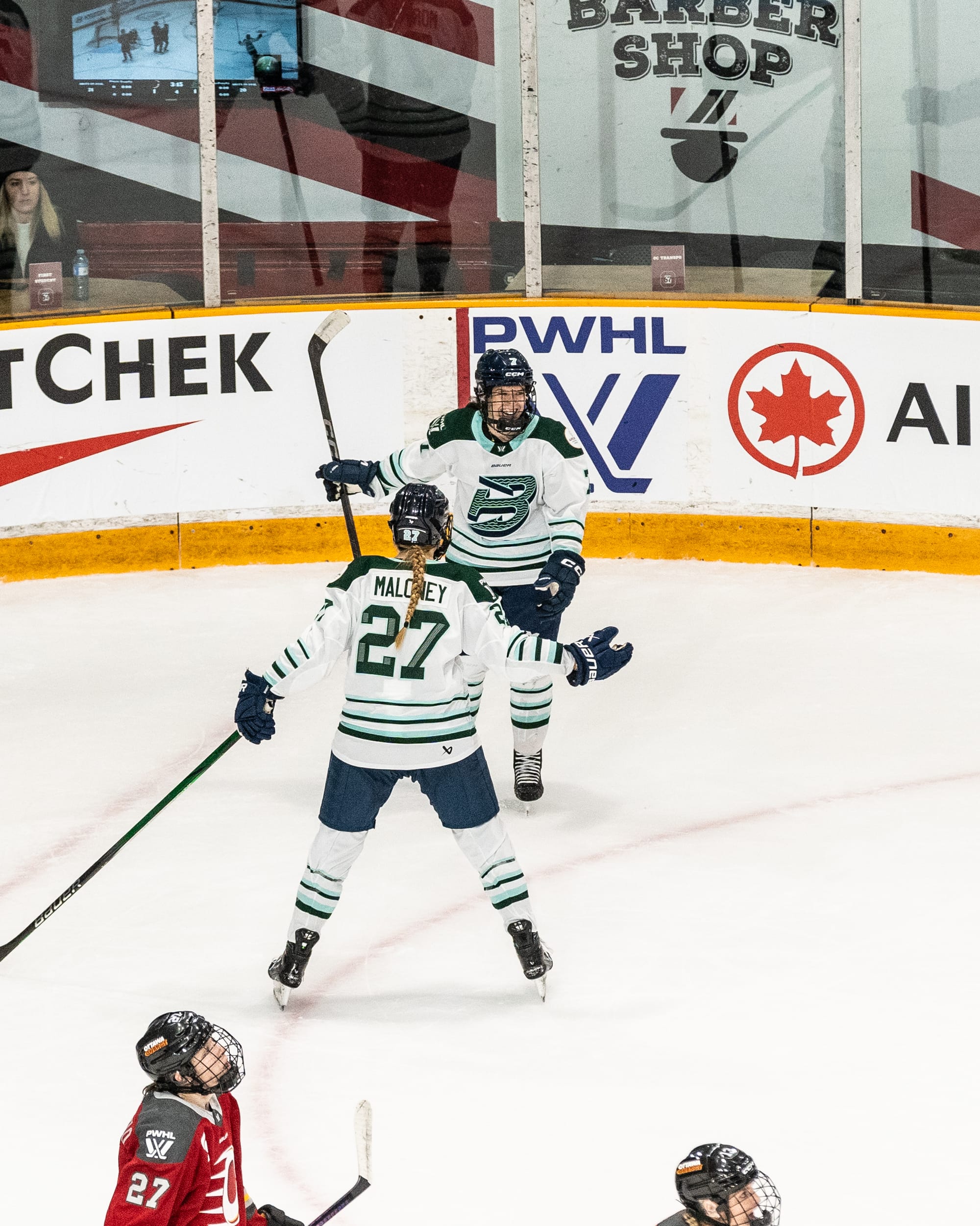 Morin and Maloney skate towards each other for a celebrator hug. They are wearing white away uniforms.