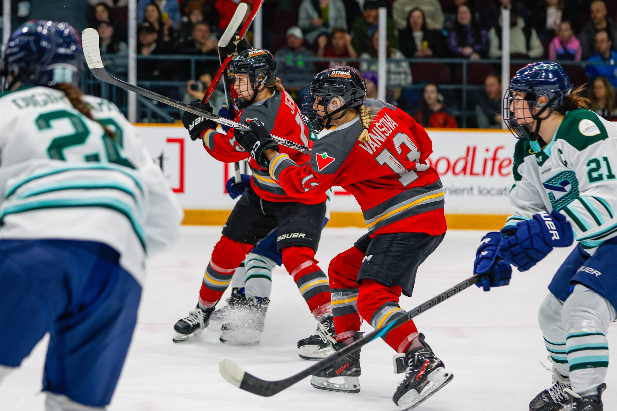 Two Ottawa players (center) battle with two Fleet players. The Charge players are wearing red home uniforms, while the Fleet players are in white.