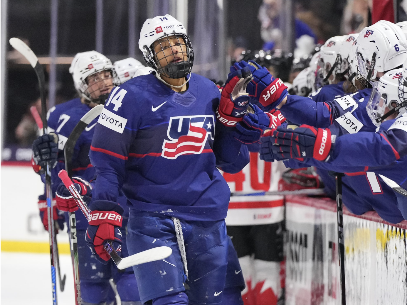 Edwards leads the handshake line at the bench. All the USA players are wearing blue uniforms.