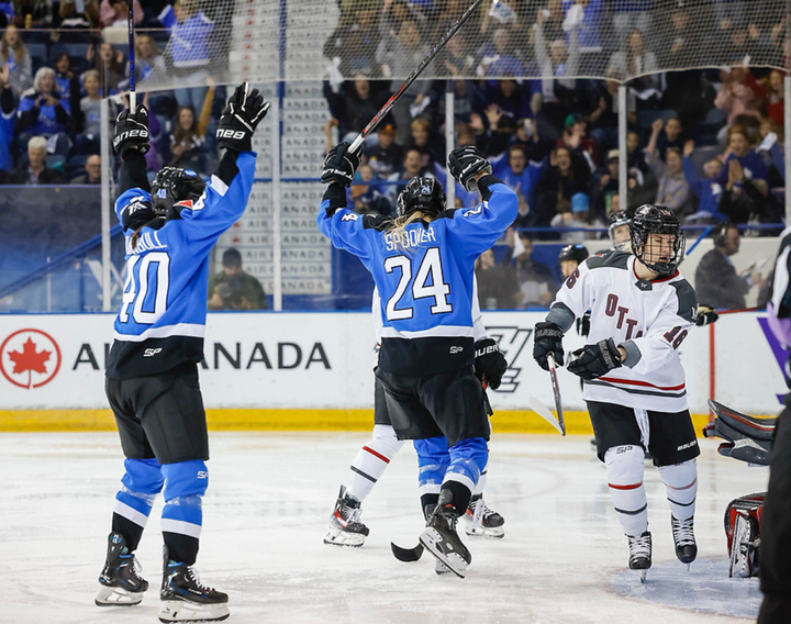 Spooner (right) and Turnbull (left) raise their arms to celebrate. Both are back-to the camera wearing blue uniforms.