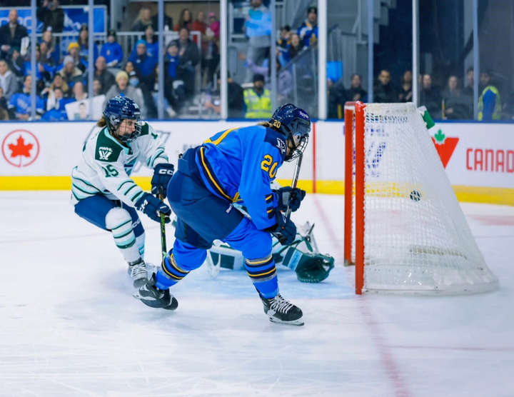 A side shot of Nurse crouched down and following through as she scores on Boston's Aerin Frankel. 