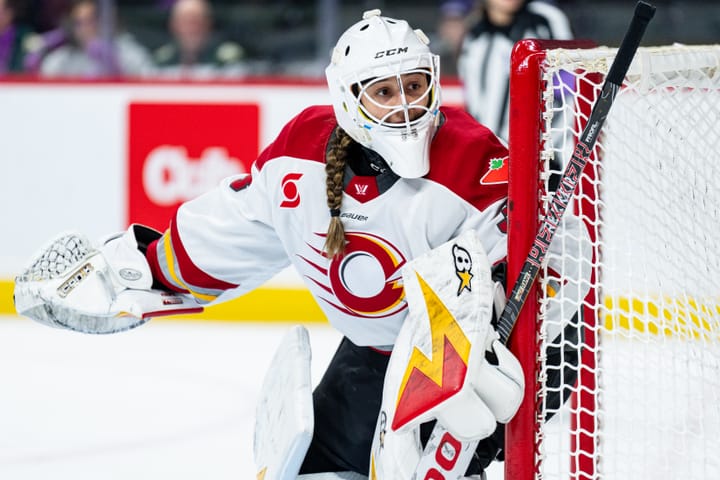 Gwyneth Philips in net looking at the corner of the rink, ready to make a save.