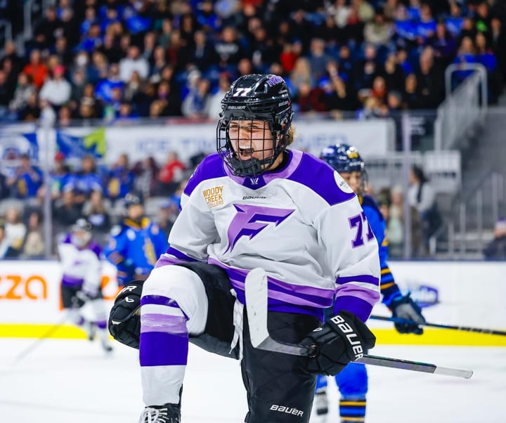 Cava raises her knee, bumps her firts, and yells in celebration. She is facing the camera and wearing a white away uniform.