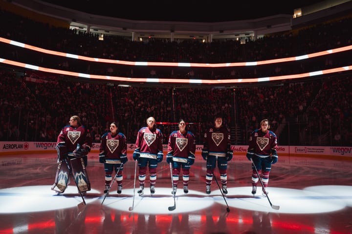 Six Montréal players stand facing the camera along the blueline under spotlights. They are wearing maroon home uniforms.