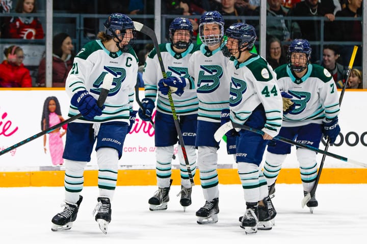 Five Fleet players smile after just breaking a group hug. They're wearing white away uniforms.